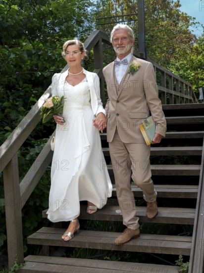 Elderly couple's wedding on wooden bridge