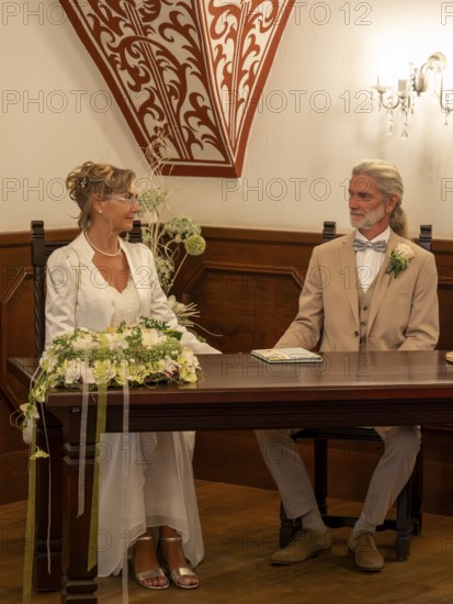 Elderly couple's wedding, registry office, attach rings