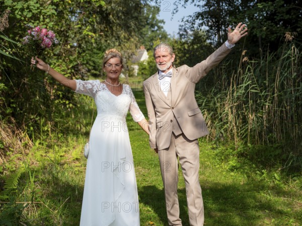 Elderly couple's wedding on a green meadow path
