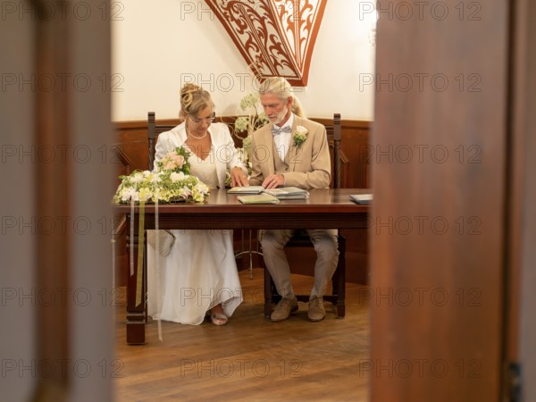 Elderly couple's wedding, registry office, attach rings