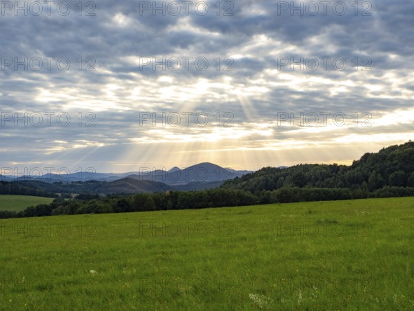 Sunbeams over gentle mountain landscape and meadows, Bohemia, Lusetian Mountains, Czech Republic
