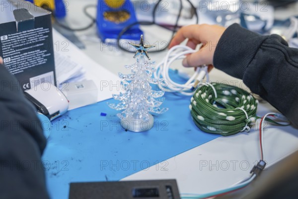 Craft table with small plastic Christmas tree and cables in hand, Jugend Forschungszentrum Nagold, Calw district, Germany