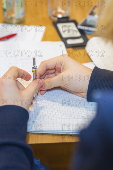 Circle holding hands while working on a notebook, Jugend Forschungszentrum Nagold, Calw district, Germany