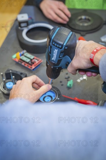 Person uses drills to secure components to a table, Jugend Forschungszentrum Nagold, Calw district, Germany