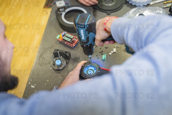 A person uses a drill in a workshop, Jugend Forschungszentrum Nagold, Calw district, Germany