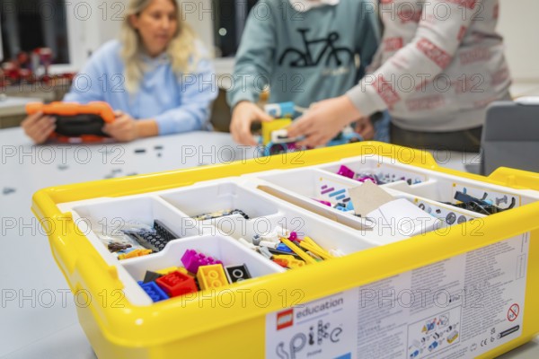 Children playing with a yellow Lego set on a table, Jugend Forschungszentrum Nagold, Calw district, Germany