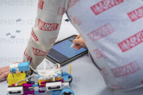 Child uses a tablet to control or design a robot, Jugend Forschungszentrum Nagold, Calw district, Germany
