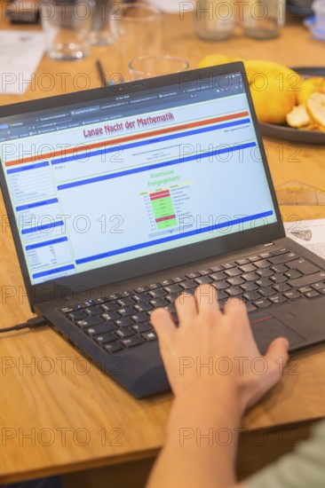 Hand operates a laptop with mathematics software on a wooden table, Jugend Forschungszentrum Nagold, Calw district, Germany