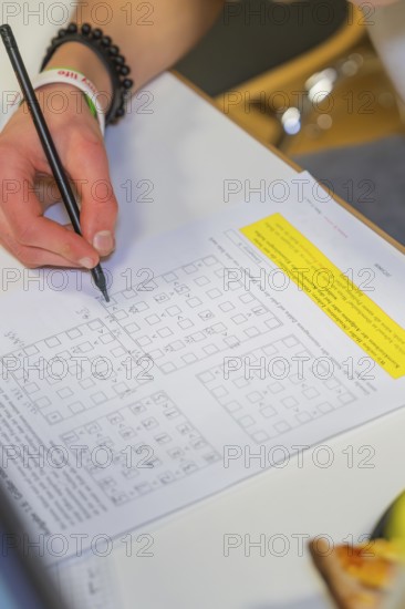 Hand writes math problems on a worksheet, Jugend Forschungszentrum Nagold, Calw district, Germany