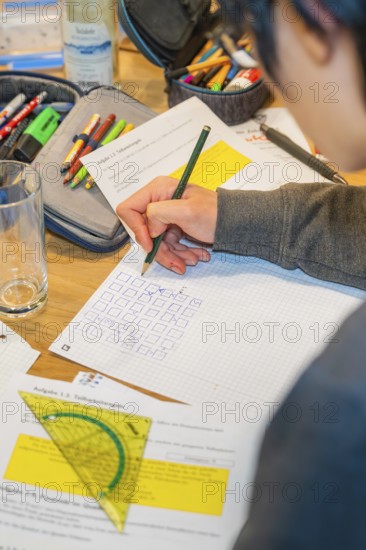 Person writes notes on paper using multiple tools, Jugend Forschungszentrum Nagold, Calw district, Germany