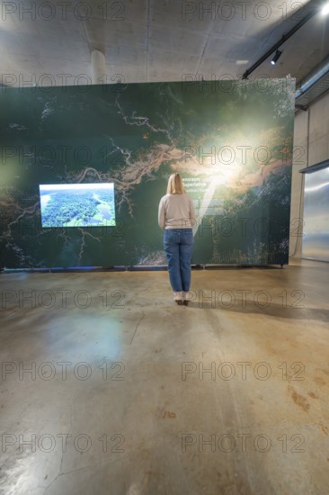 Woman looking at a wall map in a modern exhibition room, Amazonia exhibition, Gasometer, Pforzheim, Germany