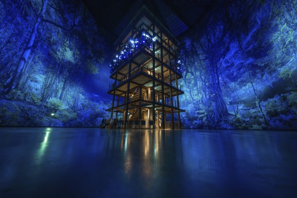 A multi-storey wooden building with blue jungle projection and artificial lighting, Amazonia exhibition, Gasometer, Pforzheim, Germany