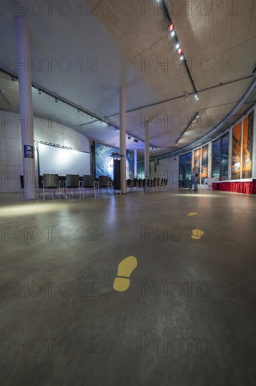 Large, modern room with yellow footprints on the floor and lighting on the ceiling, Amazonia exhibition, Gasometer, Pforzheim, Germany