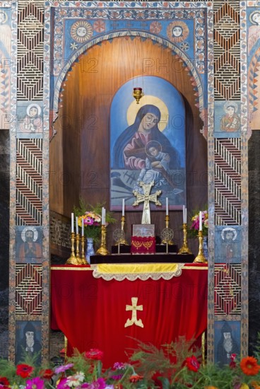 Religious altar with icon and candles richly decorated with flowers in a decorated wall niche, Sevanavank monastery, Sevan monastery, Gegharkunik province, Armenia