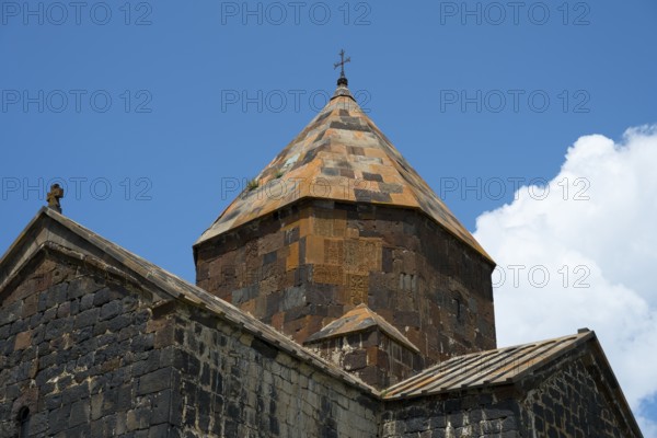 Close-up of a stone church tower with a detailed roof under a blue sky, Sevanavank monastery, Sevan monastery, Gegharkunik province, Armenia