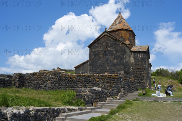 Historic stone monastery under cloudy sky in a green landscape, Sevanavank monastery, Sevan monastery, Gegharkunik province, Armenia