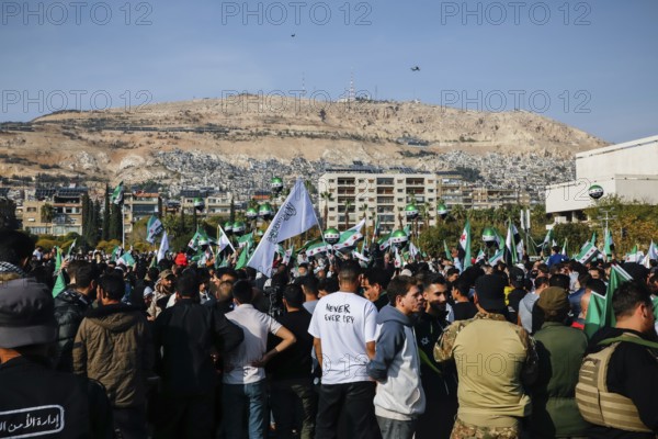 Damascus, Syria. November 28, 2025: Thousands of Syrians gather in Umayyad Square in central Damascus to celebrate the anniversary of the military operation that led to the fall of Bashar al-Assad's regime. Demonstrators express joy and unity while denouncing Israeli attacks on Syrian territory, Damascus, Damascus, Syria