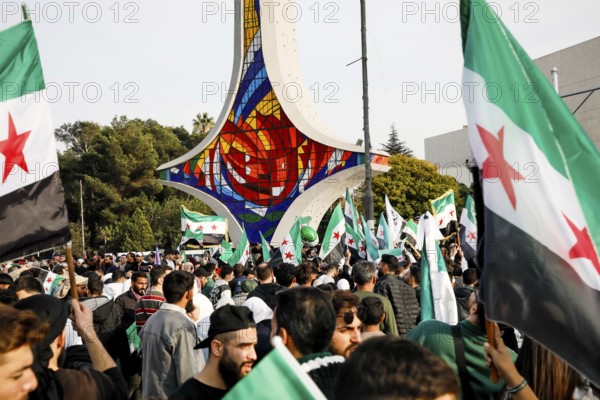 Damascus, Syria. November 28, 2025: Thousands of Syrians gather in Umayyad Square in central Damascus to celebrate the anniversary of the military operation that led to the fall of Bashar al-Assad's regime. Demonstrators express joy and unity while denouncing Israeli attacks on Syrian territory, Damascus, Damascus, Syria