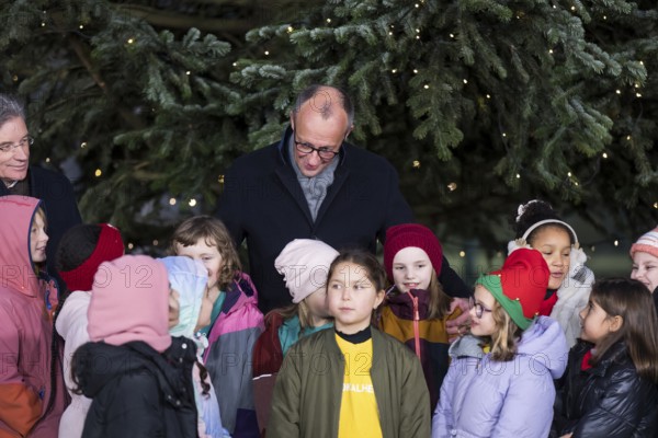 Friedrich Merz (CDU, Federal Chancellor of the Federal Republic of Germany) talks to children from the Vokalhelden Children's Choir from Schöneberg elementary schools at the handing over of the Christmas tree to the Federal Chancellery, Berlin, 28.11.2025