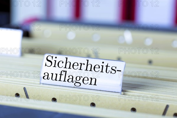 (photo montage) Sign with the words SAFETY REQUIREMENTS on a hanging file register