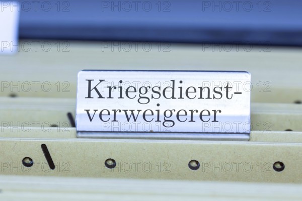 (photo montage) Sign with the inscription CONSCIENTIOUS OBJECTOR on a hanging file register