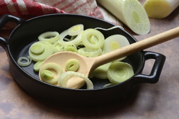 Leeks, leek rings in pan with cooking spoon, leek