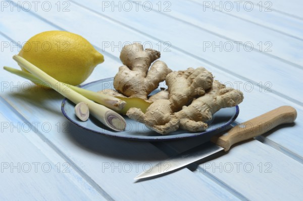 Ginger tubers with lemongrass on plate, lemon