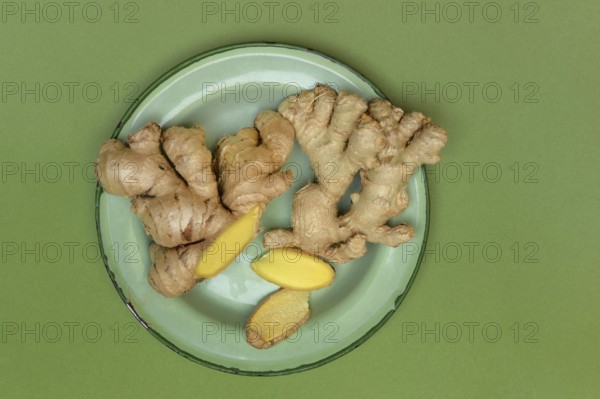 Ginger tubers and ginger slices on plate, Zingiber officinale