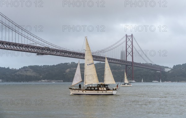The Ponte 25 de Abril, 3.2 km long bridge in Portugal with a 2278 meter long suspension bridge across the Tagus, cloudy and rainy weather, third-longest suspension bridge with combined road and rail traffic, Lisbon, Portugal