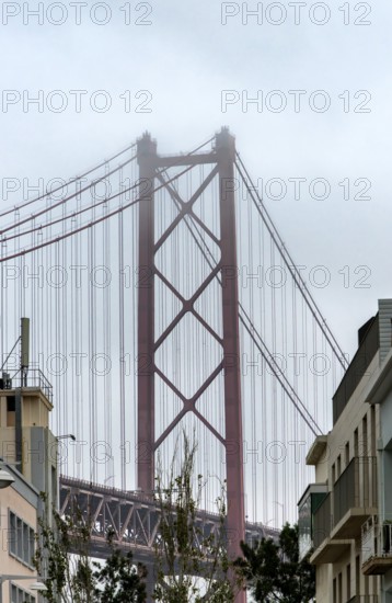 The Ponte 25 de Abril, 3.2 km long bridge in Portugal with a 2278 meter long suspension bridge across the Tagus, cloudy and rainy weather, third-longest suspension bridge with combined road and rail traffic, Lisbon, Portugal