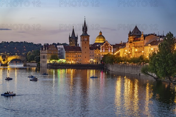 Vltava embankment with Old Town Water Tower, NovotnÃ½ Bridge and Charles Bridge at dusk, Prague, Czech Republic