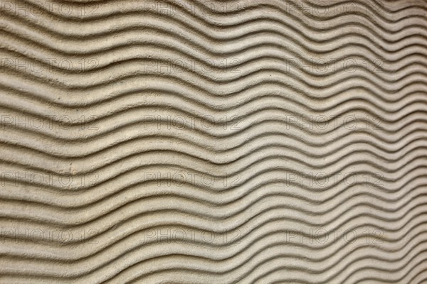 Close-up of beige sand texture with curved lines