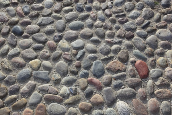 Round paving made of multi-coloured stones with a rough surface