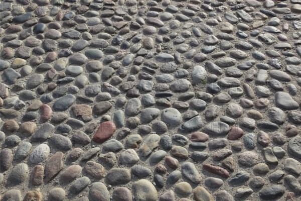A floor of gray, round cobblestones with an uneven surface