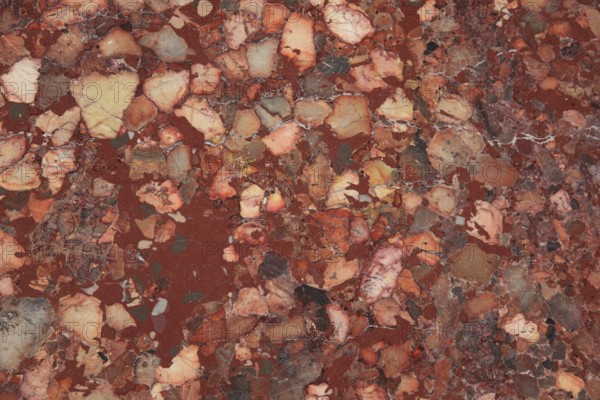 Red and brown marble with intense color variations and textured surface