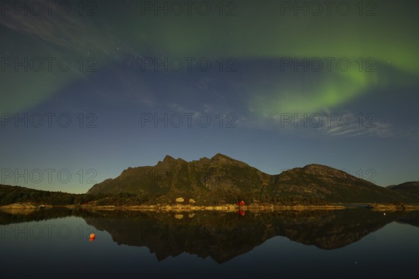 Northern lights are reflected in the fjord in Norway. Aurora Borealis over FestvÃ¥g near BodÃ¸, Nordland, Norway
