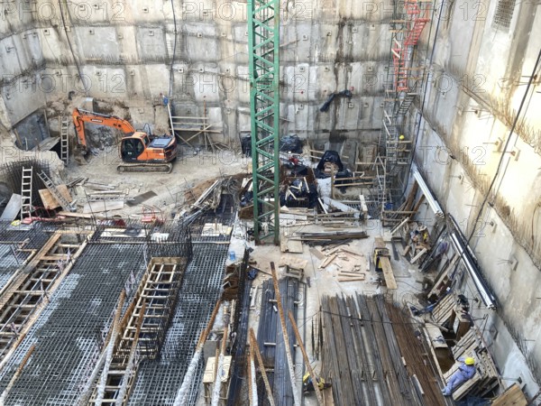 View of a construction site in a deep excavation pit, concrete work with lots of reinforcements, foundations for a high-rise building, Buenos Aires, Argentina
