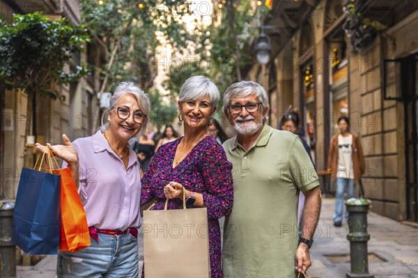 Happy senior friends smiling together on a bright european city street, enjoying a leisurely day of shopping, sightseeing and relaxed urban walking with shopping bags