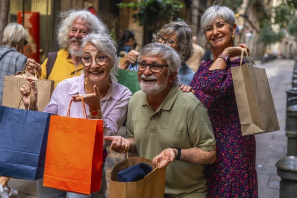 Happy group of smiling senior friends holding shopping bags while enjoying a leisure day out in the city, representing active retirement and consumerism