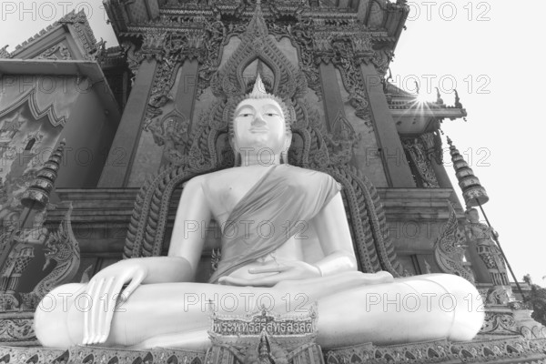 Buddha statue with tunic, Bhumispara mudra, Buddha Gautama at the moment of enlightenment, at the entrance to Wat Sitthawararam, Bangkok, Thailand