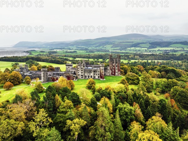 Autumn colours over Penrhyn Castle and Garden from a drone, Llandygai, Bangor, Gwynedd, North Wales, UK