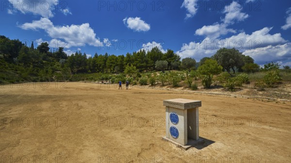 Open antique stadium with surrounding trees under a sunny sky, Ancient Stadium, Nemea, Peloponnese, Greece