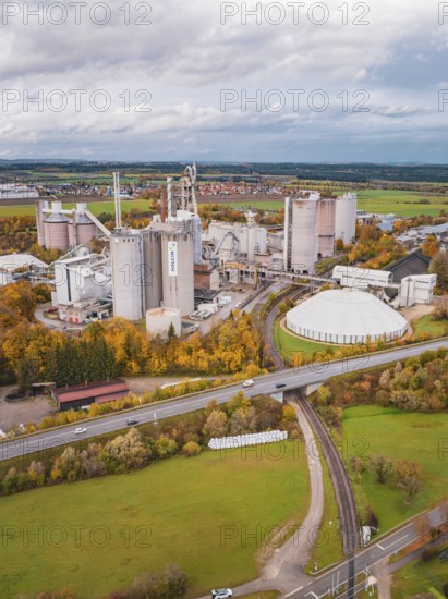 A view from above of an extensive industrial complex in the midst of an autumn landscape