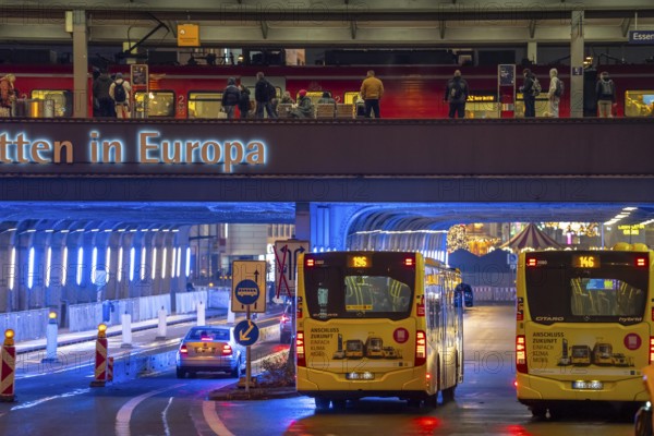 The main train station in Essen, blue illuminated underpass, bus station, am Europaplatz, train on the platform, North Rhine-Westphalia, Germany