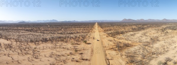 Travel, aerial view, car driving on road through arid landscape, Kunene region, Namibia