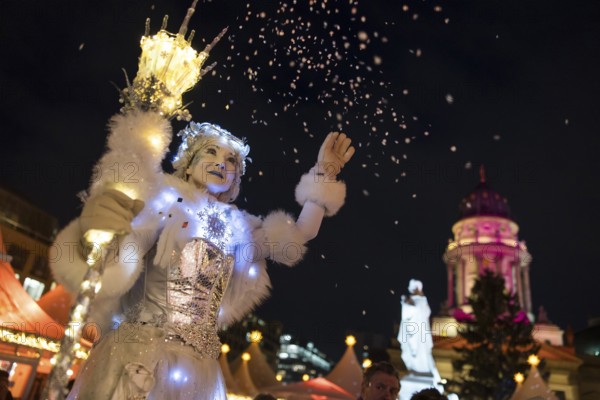 A Black-winged Stilt walker throws confetti at the Christmas market WeihnachtsZauber Gendarmenmarkt on Gendarmenmarkt, Berlin, 24.11.2025