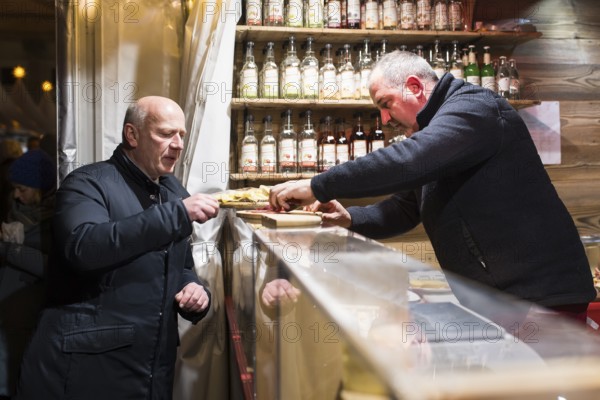 Kai Wegner, Governing Mayor of Berlin, receives sausages at the Zillertaler RÃ¤ucherspreck stand at the WeihnachtsZauber Gendarmenmarkt on the Gendarmenmarkt, Berlin, 24.11.2025