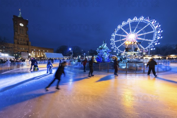 Skaters in front of the Red Town Hall, Neptune Fountain and a Ferris wheel at the Berlin Christmas market on Alexanderplatz, Berlin, 24.11.2025