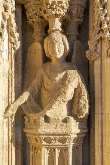Carved stone figure of winged angel on West Front of Exeter cathedral church, Exeter, Devon, England, UK