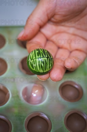 A hand-decorated green ball with Christmas greetings is presented, Weihnachtsbacken, Haselstaller Hof, Wildberg, Calw district, Germany